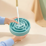 Gamelle anti-glouton Mazzed bleue en forme de labyrinthe en cours de nettoyage sous un robinet de cuisine